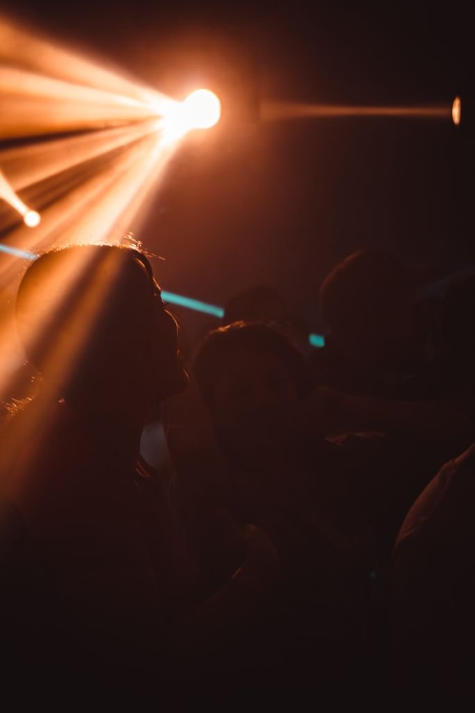 Energetic nightlife atmosphere with silhouetted figures under dramatic lighting in a nightclub.